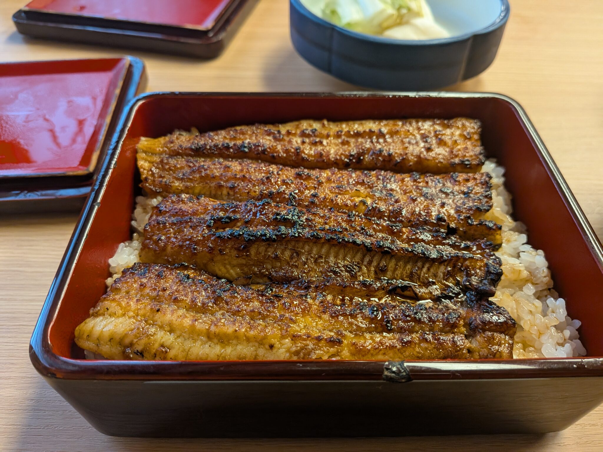 Golden glazed unagi (eel) served in traditional lacquer box at Honma restaurant in Iiyama