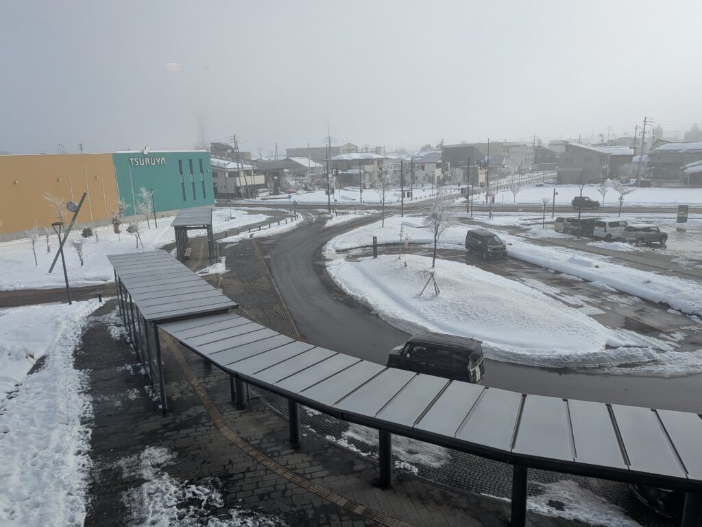 Snowy roundabout at Iiyama Station with taxi stand and bus stops for ski resort access